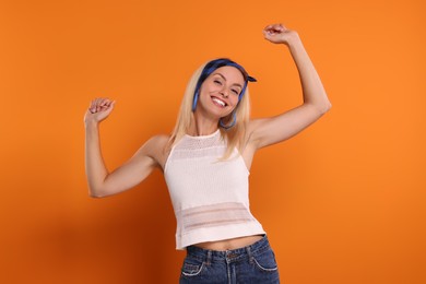 Portrait of smiling hippie woman on orange background