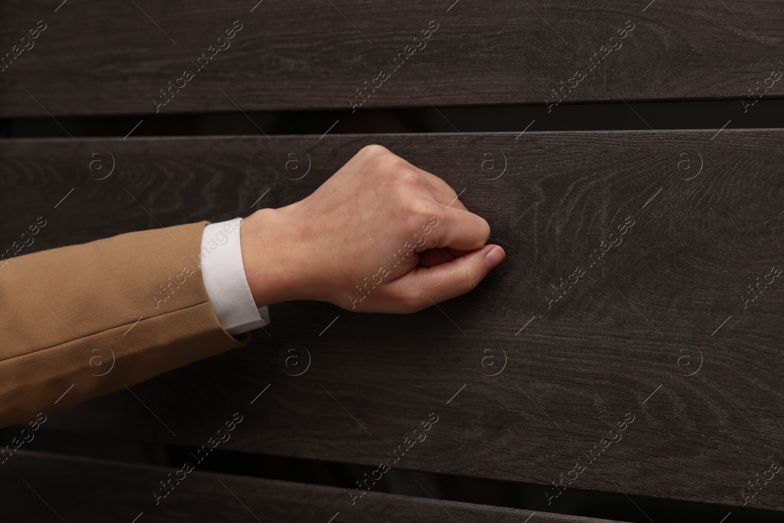 Photo of Collector knocking on door indoors, closeup view