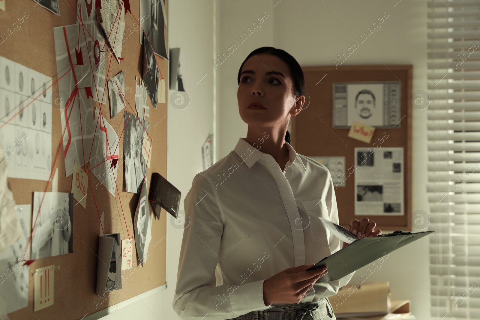 Photo of Detective looking at evidence board in office