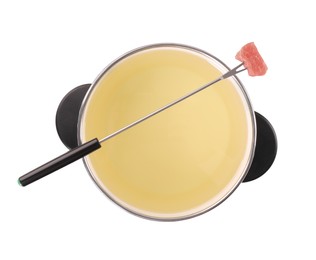 Photo of Oil in fondue pot and fork with piece of raw meat isolated on white, top view