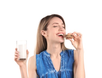 Photo of Beautiful young woman drinking milk with cookies on white background