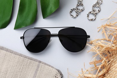 Photo of New stylish sunglasses and earrings on white background, flat lay
