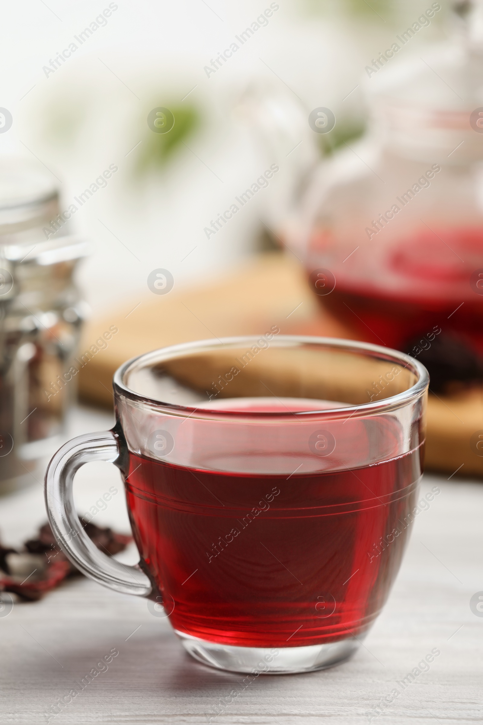 Photo of Delicious hibiscus tea on white wooden table, closeup