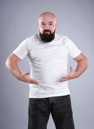 Fat man on grey background. Weight loss