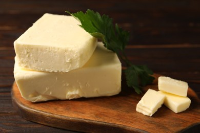 Photo of Tasty butter and parsley on wooden table, closeup