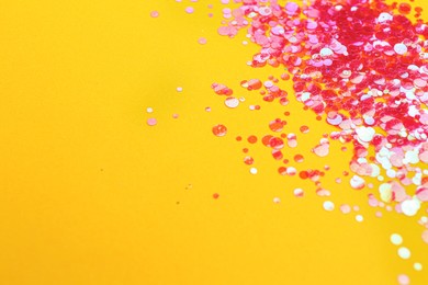 Shiny bright pink glitter on yellow background. Space for text