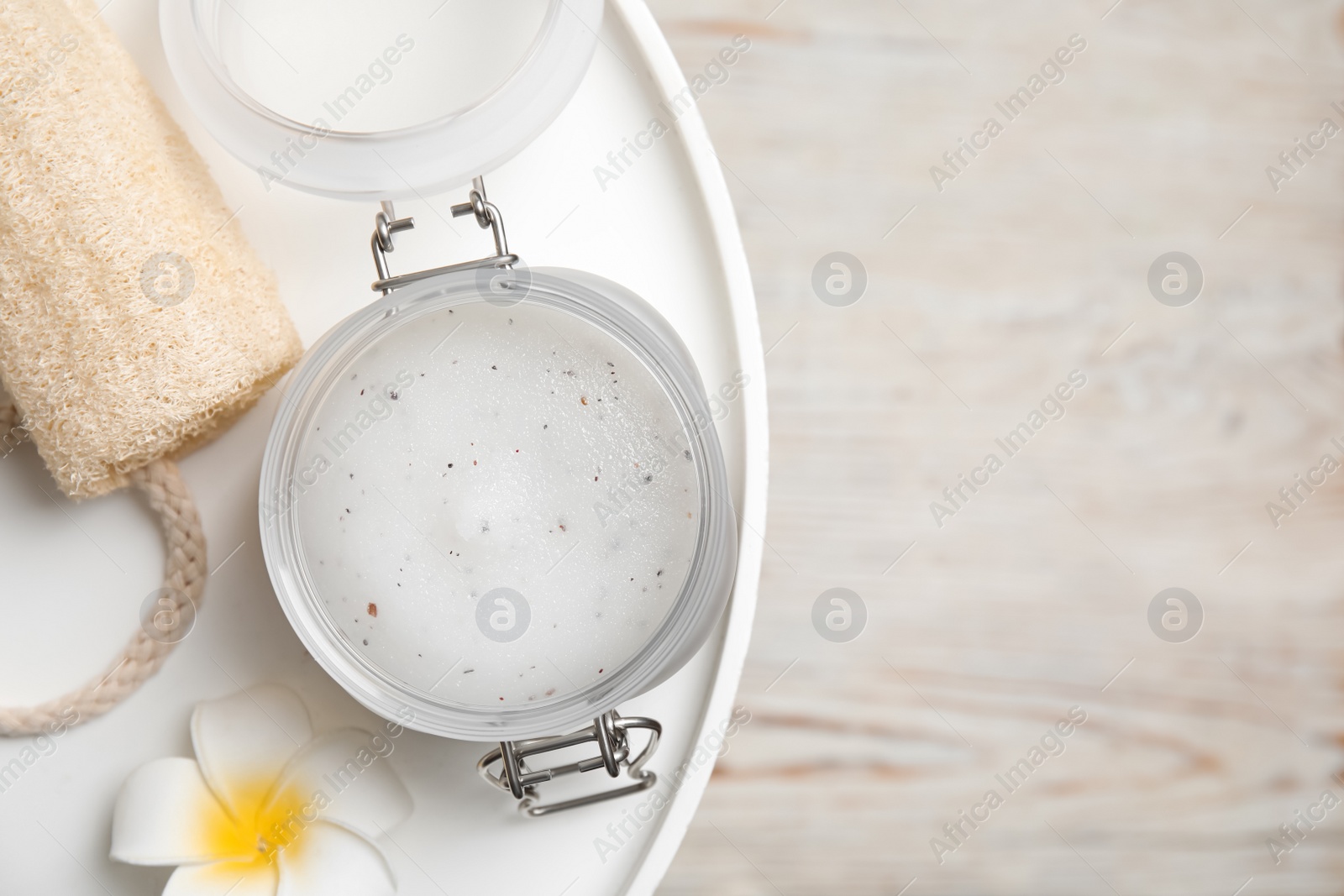 Photo of Salt scrub, loofah and plumeria  on white table, top view. Space for text