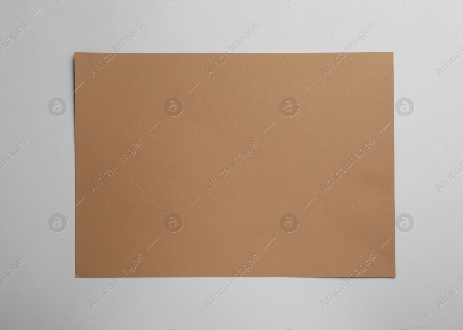 Photo of Sheet of brown paper on white background, top view