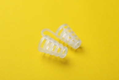 Photo of Anti-snoring device for nose on yellow background