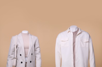 Photo of Male and female mannequins dressed in stylish outfits on beige background