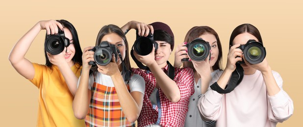 Image of Group of professional photographers with cameras on beige background. Banner design