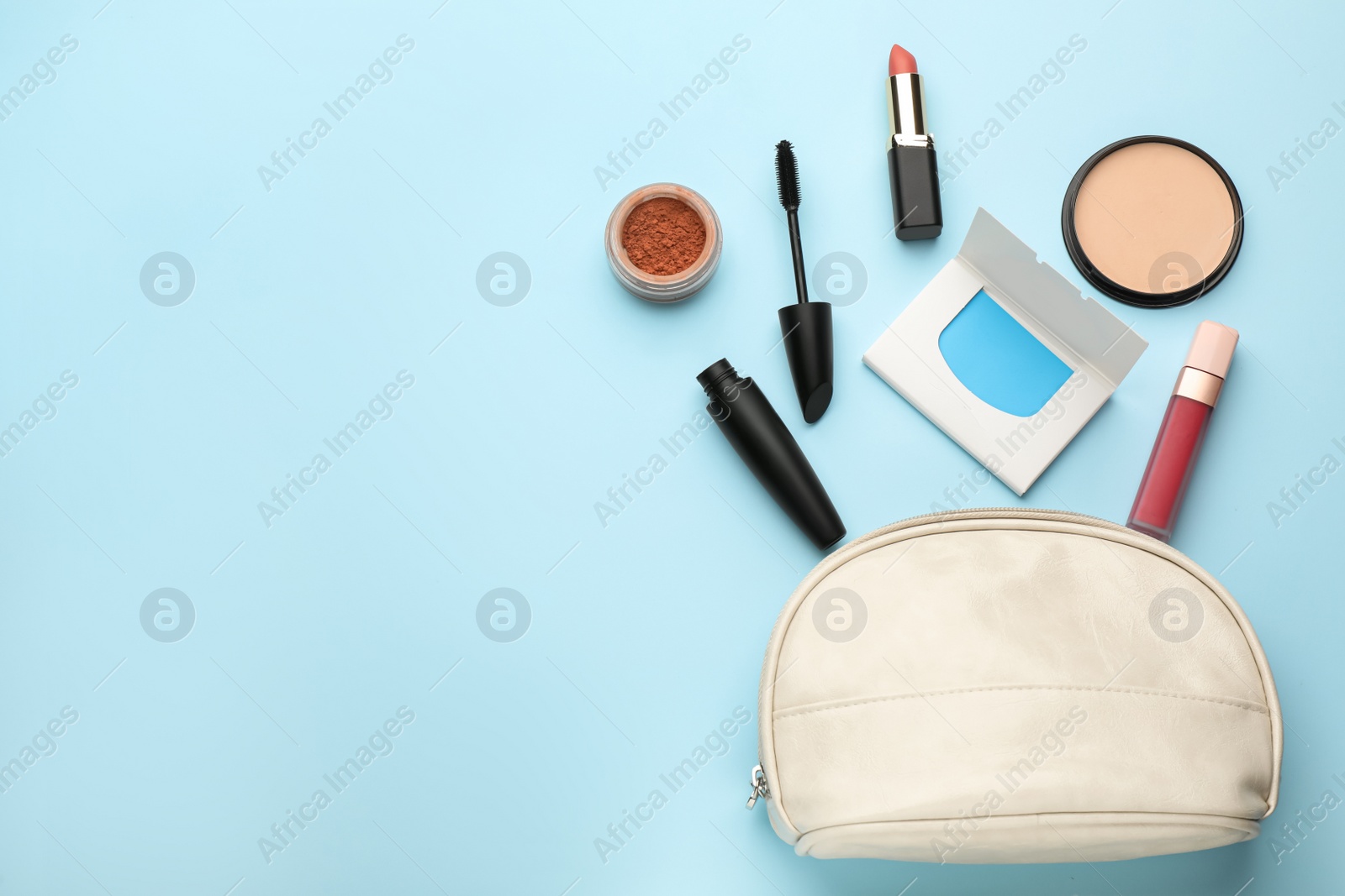 Photo of Flat lay composition with facial oil blotting tissues and makeup products on light blue background, space for text. Mattifying wipes