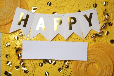 Photo of Flat lay composition with word HAPPY and party decor on yellow background. Space for text