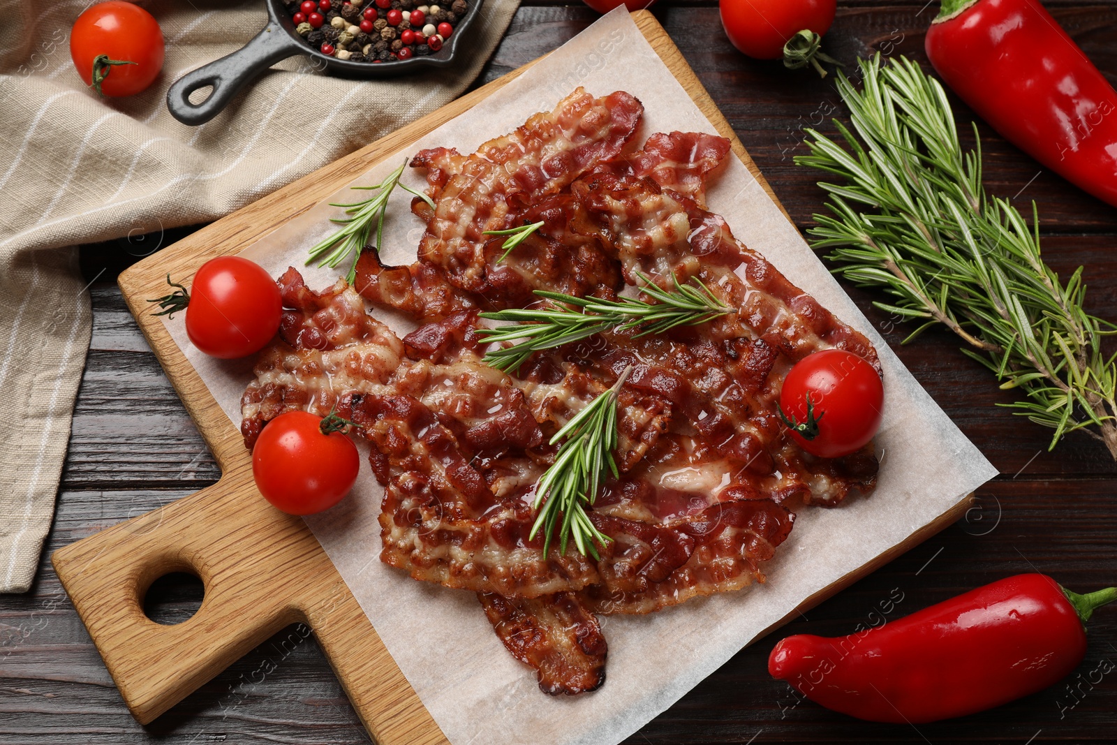 Photo of Slices of tasty fried bacon, tomatoes and different spices on wooden table, top view