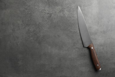 Photo of One knife on grey textured table, top view. Space for text