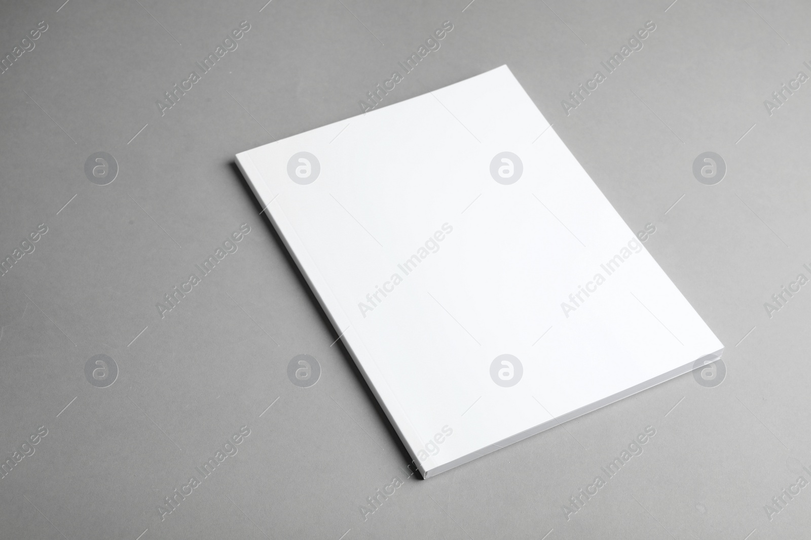 Photo of Brochure with blank cover on grey background. Mock up for design