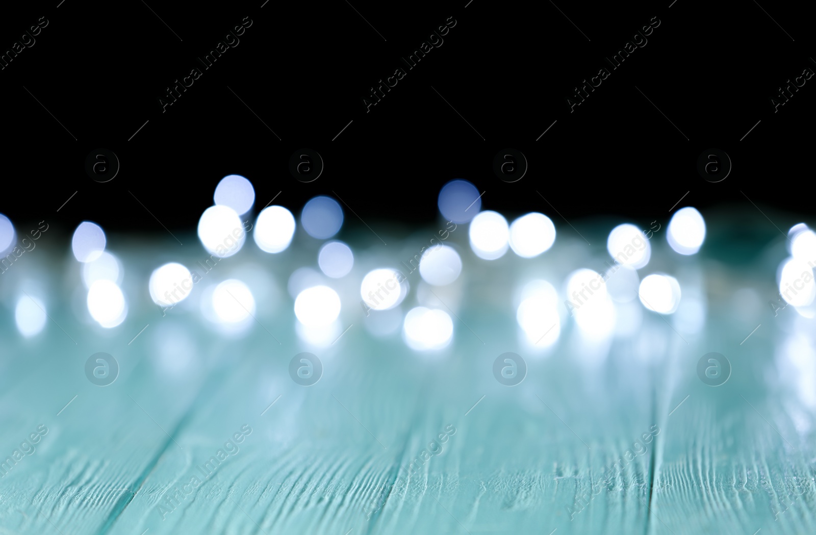 Photo of Blurred view of festive lights on dark background. Bokeh effect