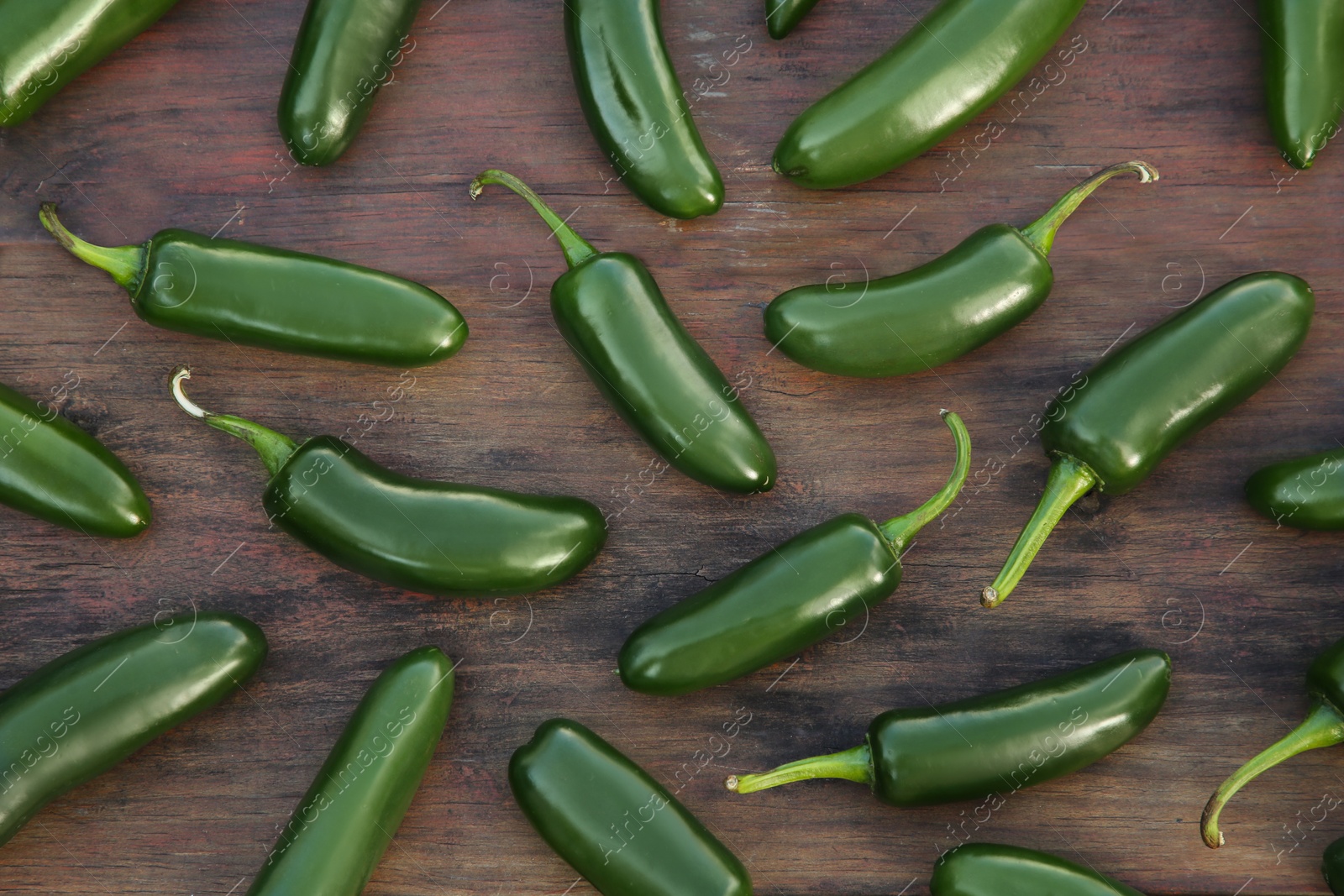 Photo of Many fresh green jalapeno peppers on wooden table, flat lay
