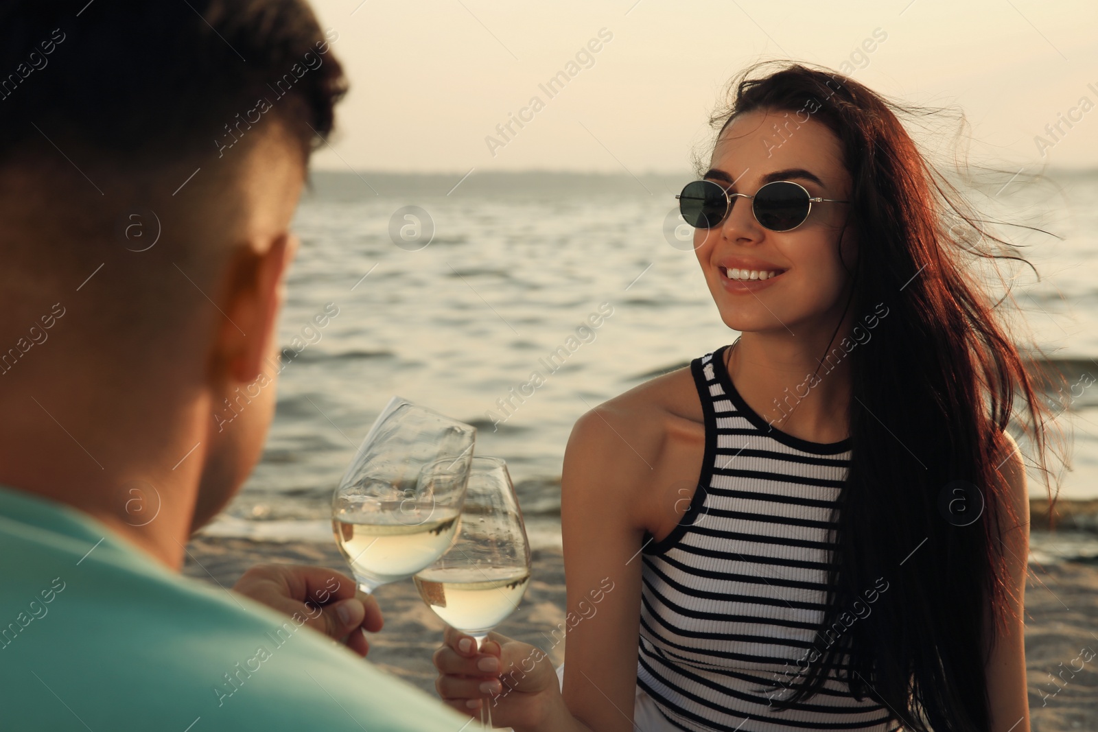 Photo of Lovely couple having picnic near river at sunset