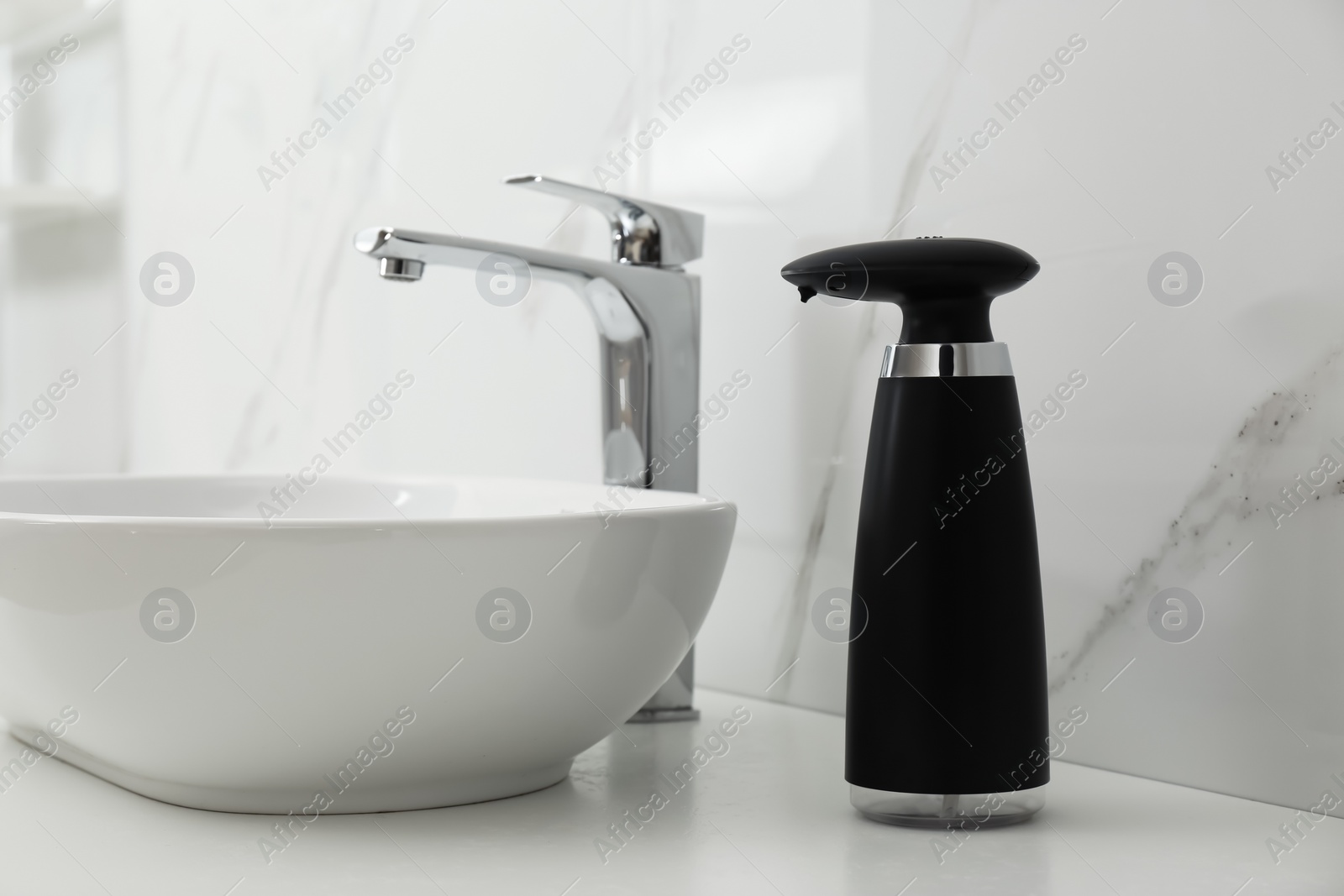 Photo of Modern automatic soap dispenser near sink in bathroom, closeup