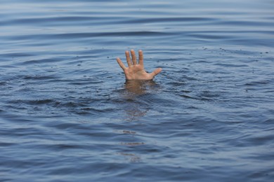 Photo of Drowning man reaching for help in sea, closeup