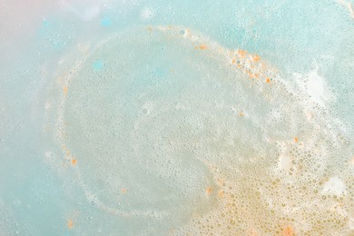 Colorful foam after dissolving bath bomb in water, closeup