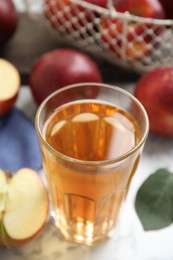 Photo of Glass of delicious apple cider on white marble table, closeup