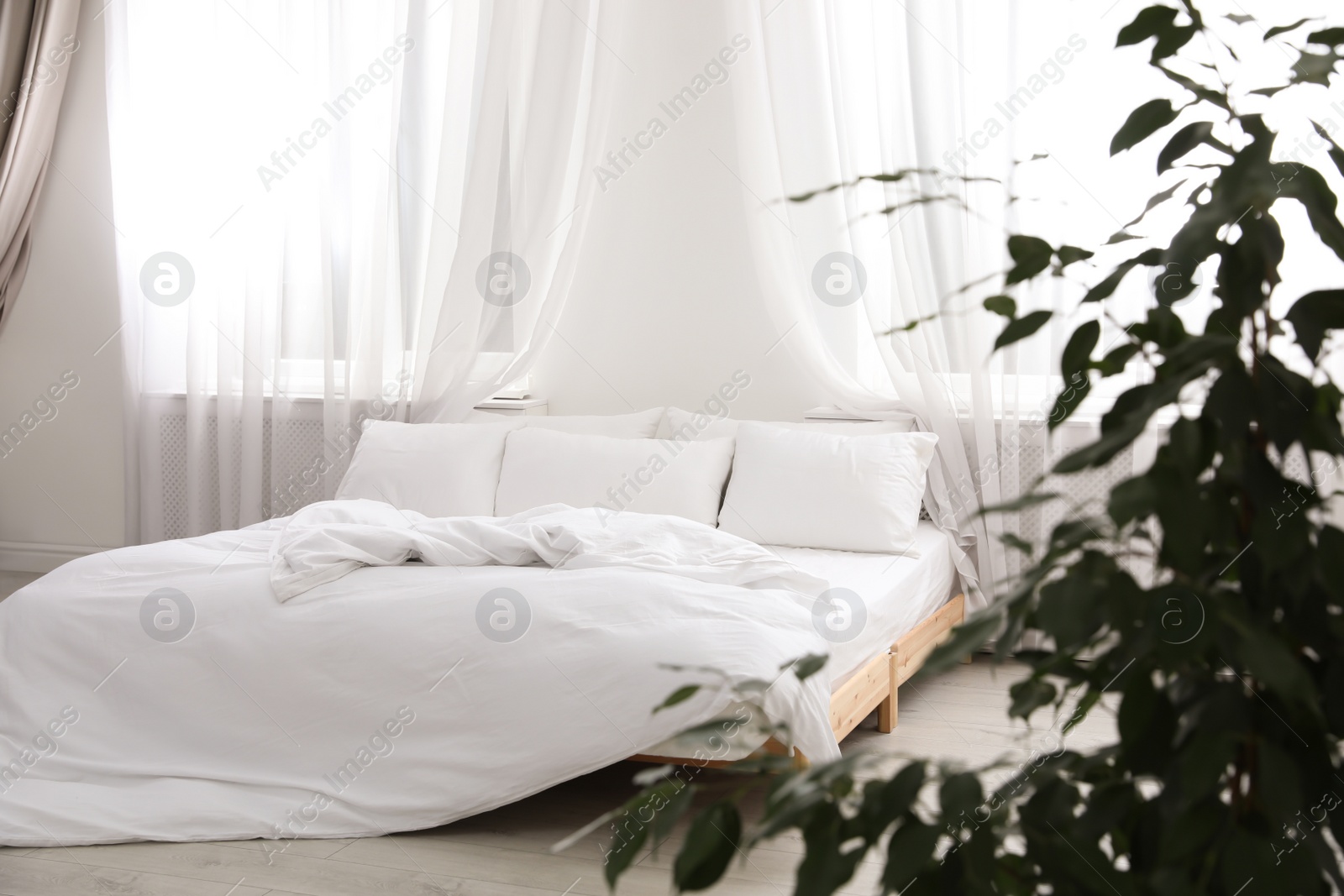 Photo of Comfortable bed with soft pillows in room interior