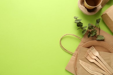 Photo of Flat lay composition with eco friendly products on light green background, space for text