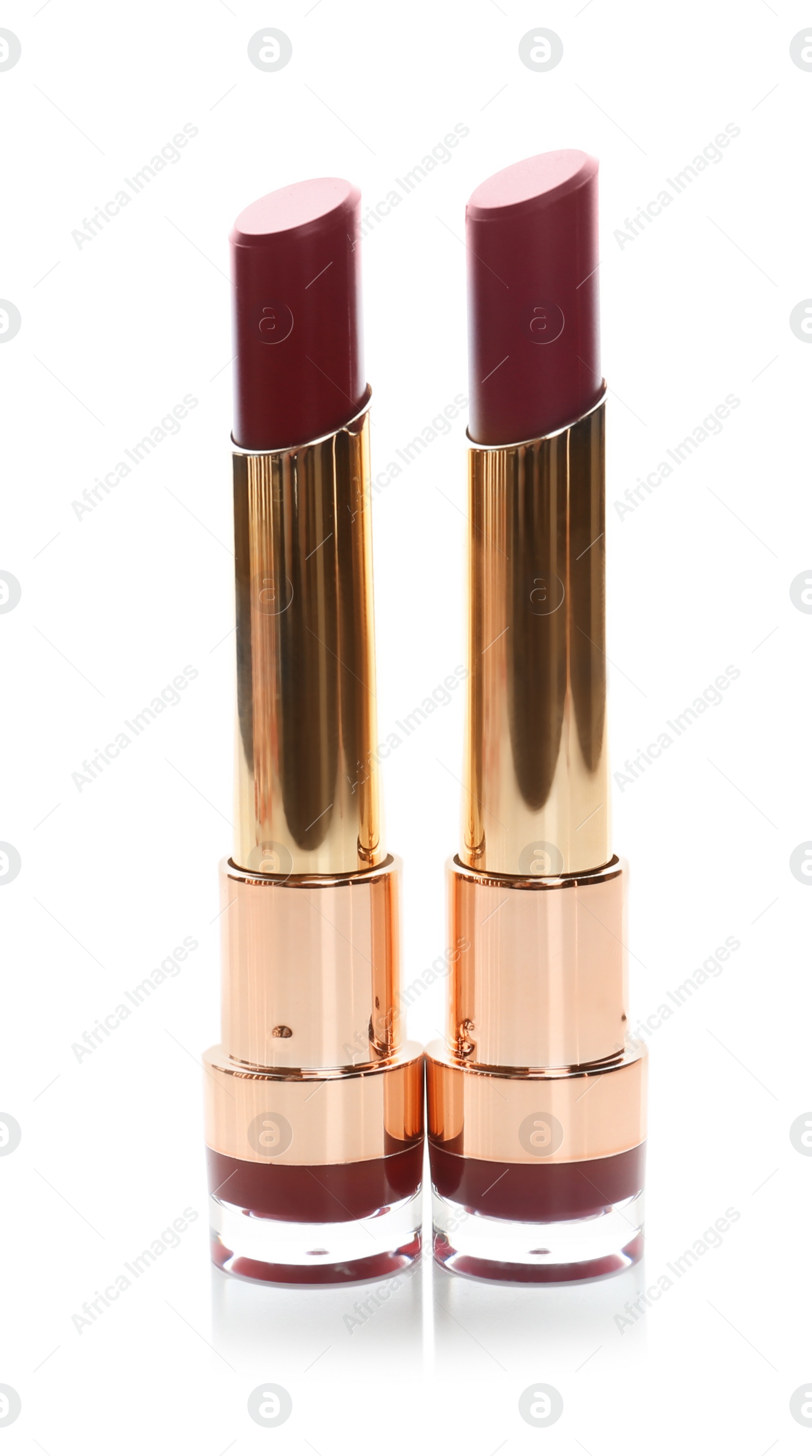 Photo of Two beautiful lipsticks on white background. Trendy makeup products