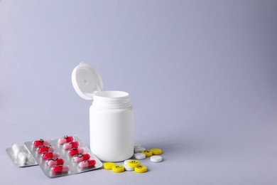 Photo of Antidepressants with different emoticons and medical jar on light grey background, space for text