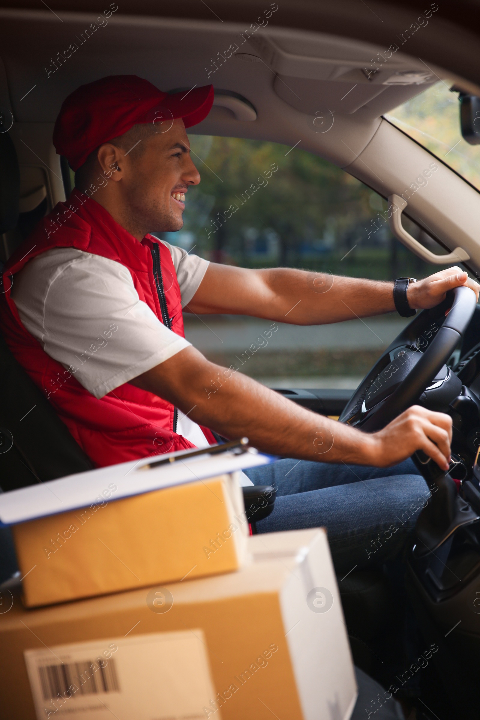 Photo of Courier in uniform on driver's seat of car