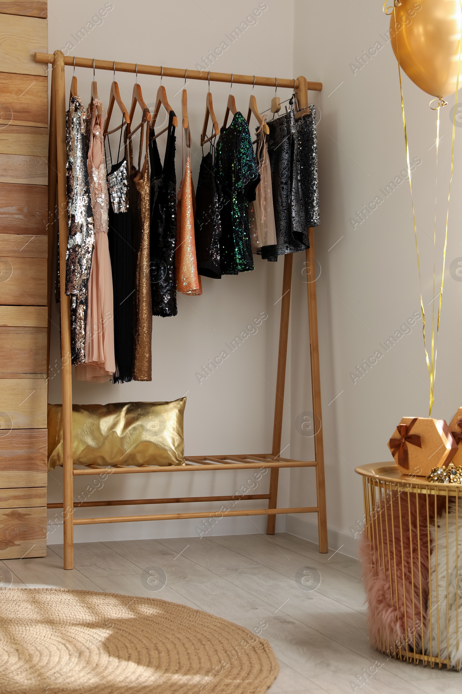 Photo of Rack with stylish women's clothes in room. Interior design