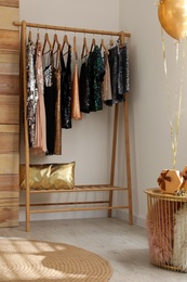 Rack with stylish women's clothes in room. Interior design