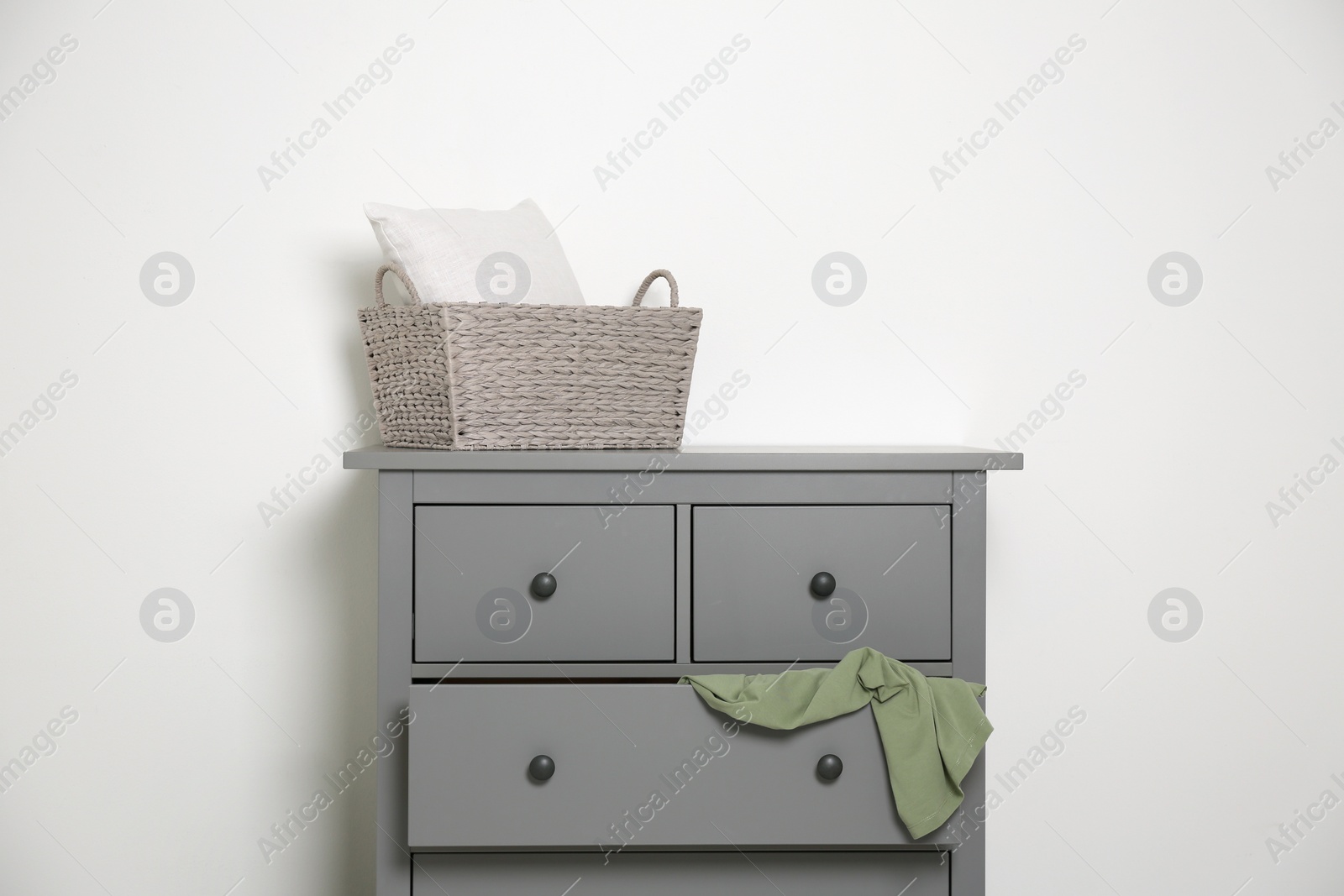 Photo of Grey chest of drawers on light background