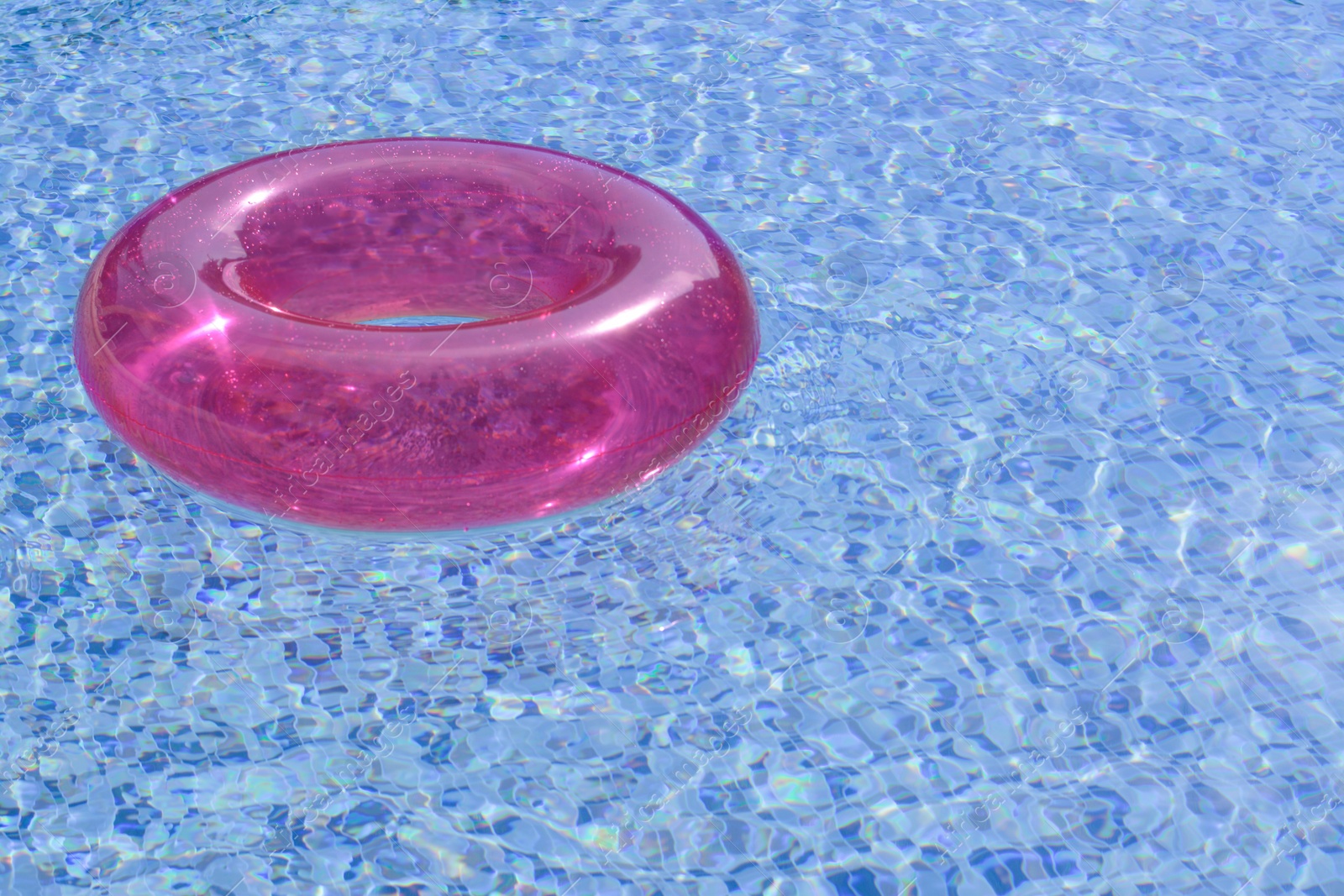 Photo of Inflatable ring floating on water in swimming pool, space for text