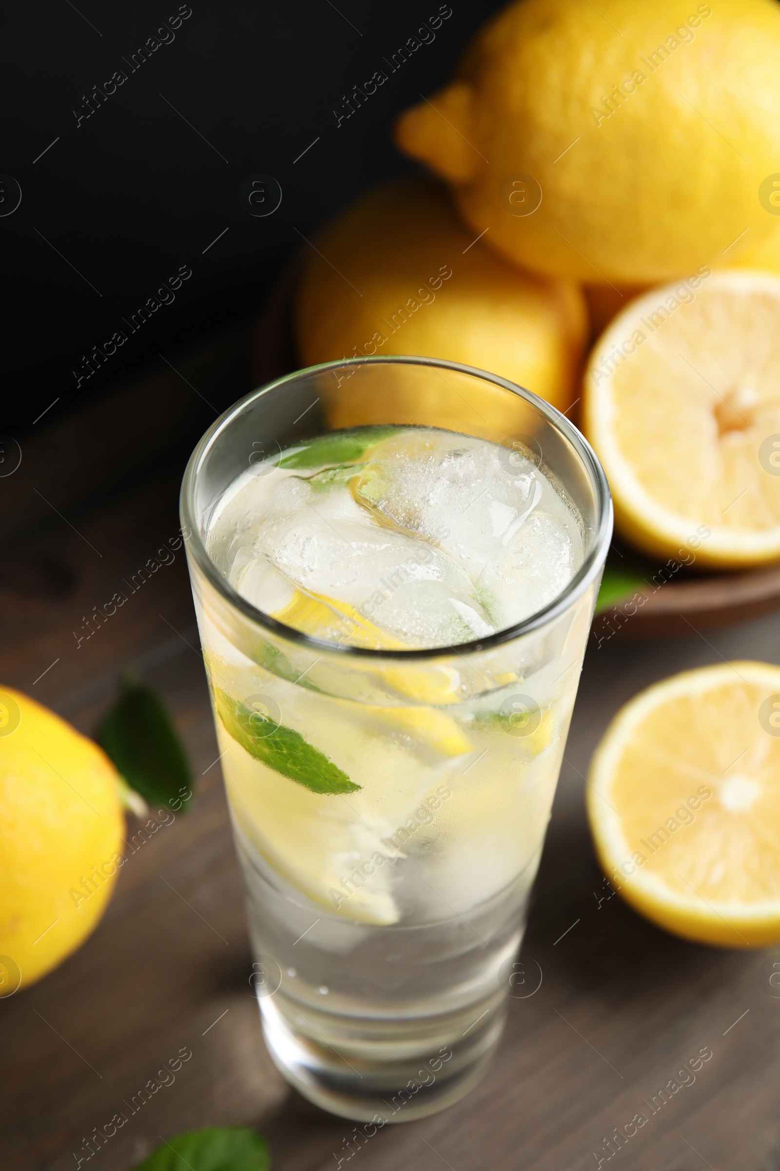 Photo of Cool freshly made lemonade and fruits on wooden table