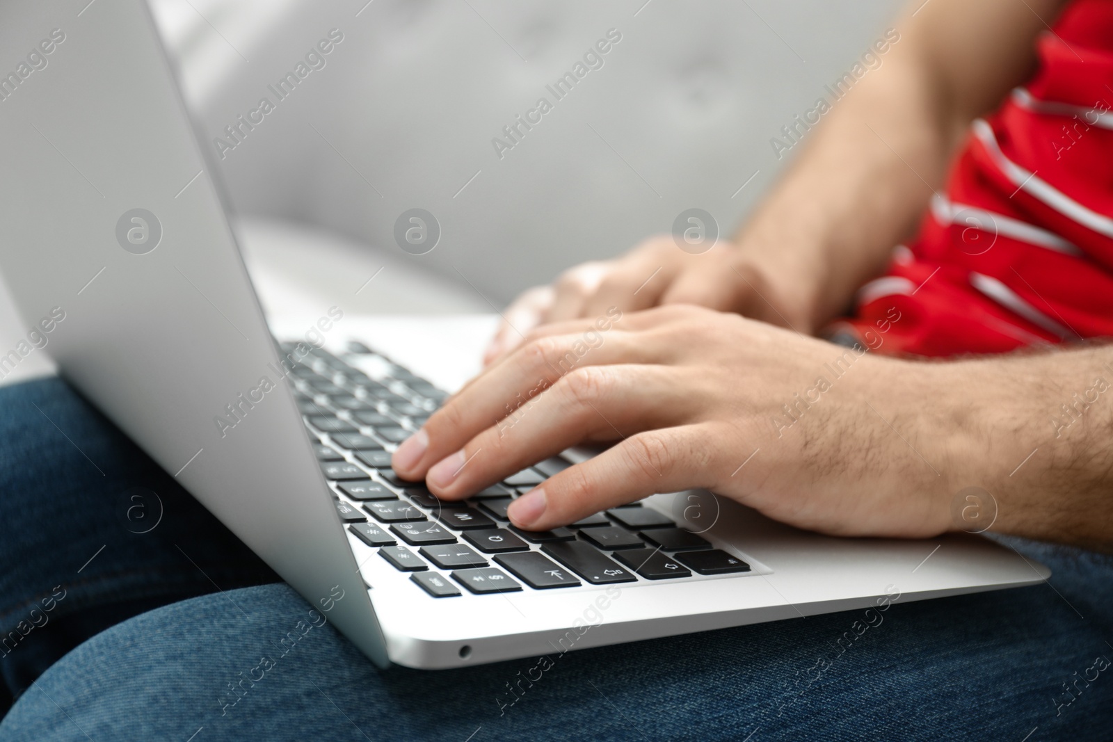 Photo of Man working on modern laptop at home, closeup