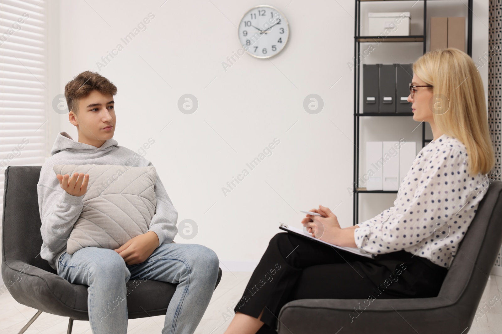 Photo of Psychologist working with teenage boy in office