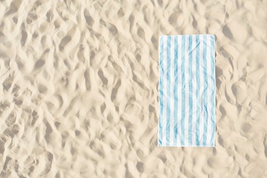 Striped beach towel on sand, aerial view. Space for text