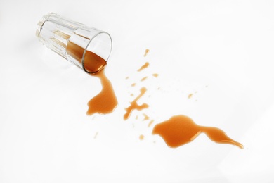 Photo of Overturned glass of cola on white background