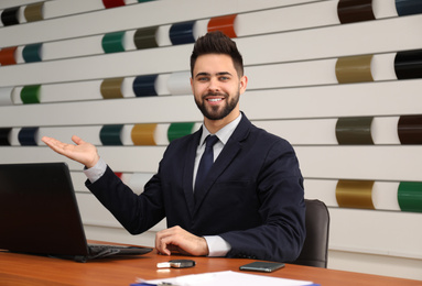 Salesman working at desk in car dealership