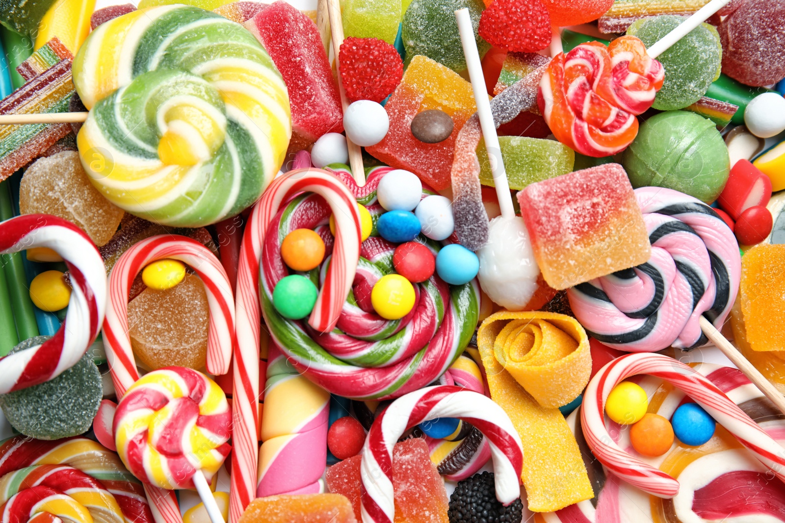 Photo of Many different yummy candies as background, top view