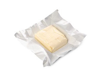 Block of tasty butter in open foil packaging isolated on white