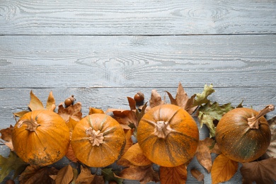 Photo of Ripe pumpkins on wooden background, flat lay with space for text. Holiday decoration