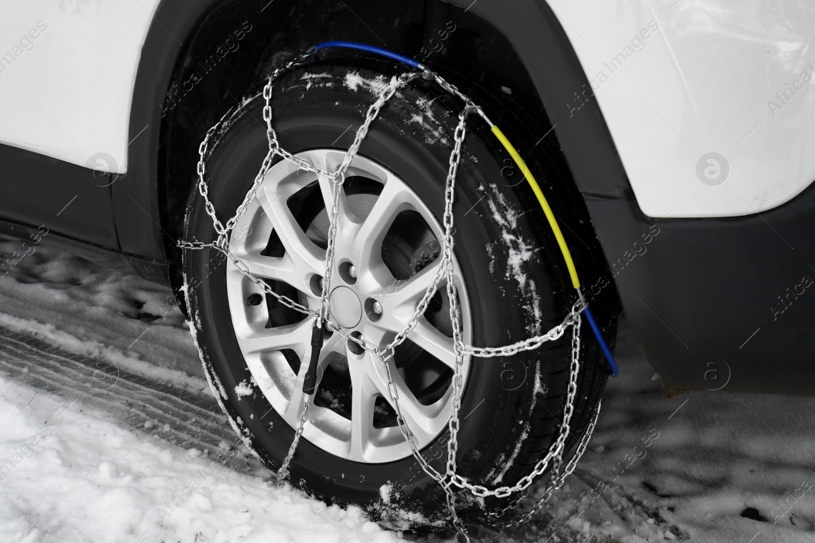 Photo of Car with snow chain on tire, closeup. Winter season