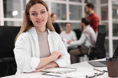 Team of employees working together in office. Happy woman at table indoors