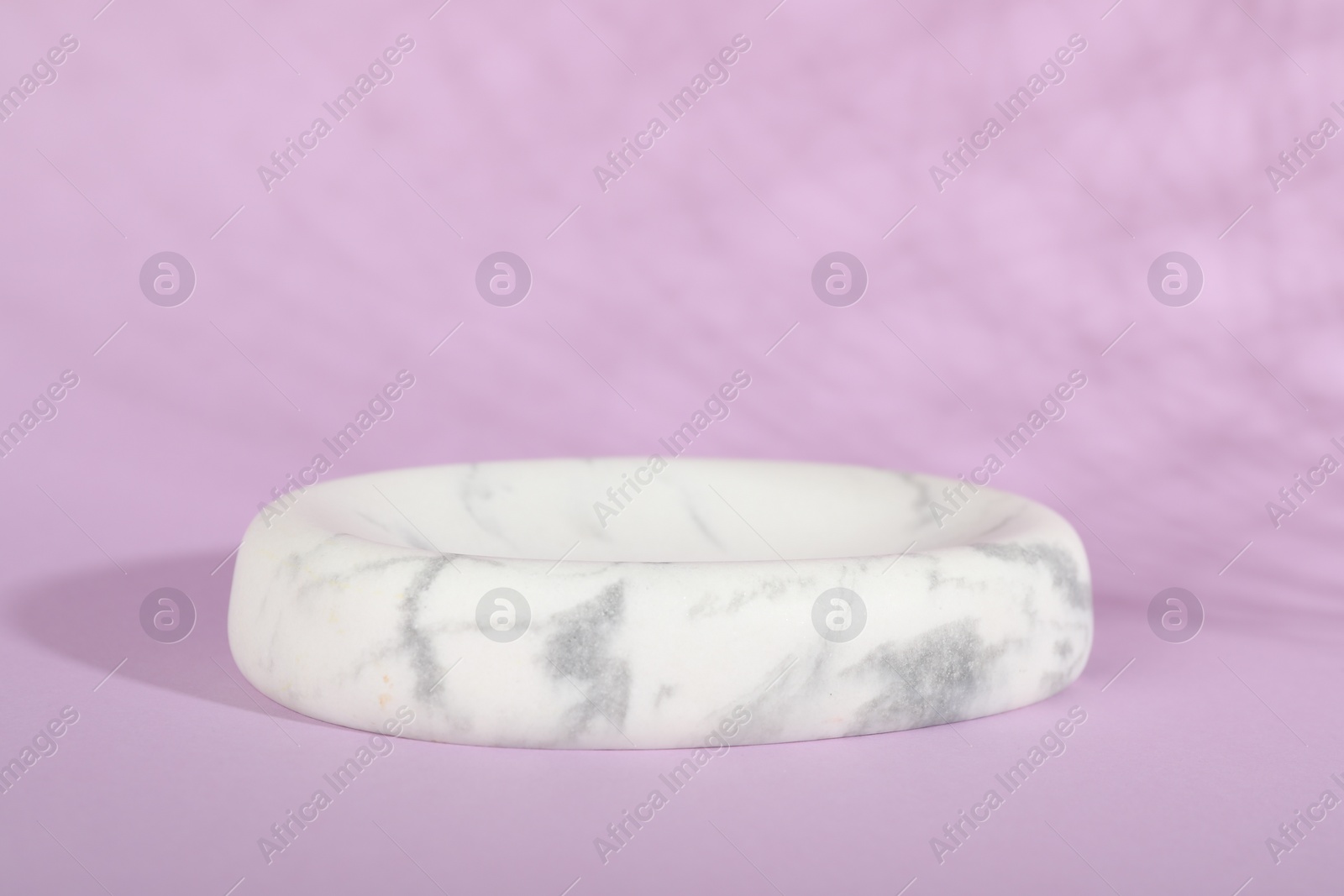 Photo of Presentation of product. White marble podium on violet background, space for text
