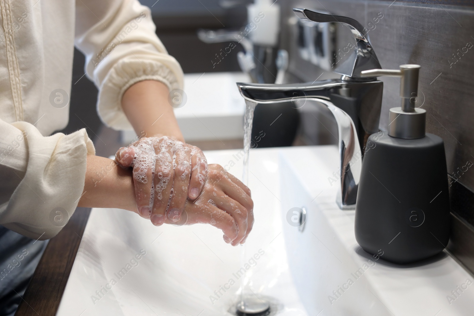 Photo of Woman washing hands in bathroom, closeup view