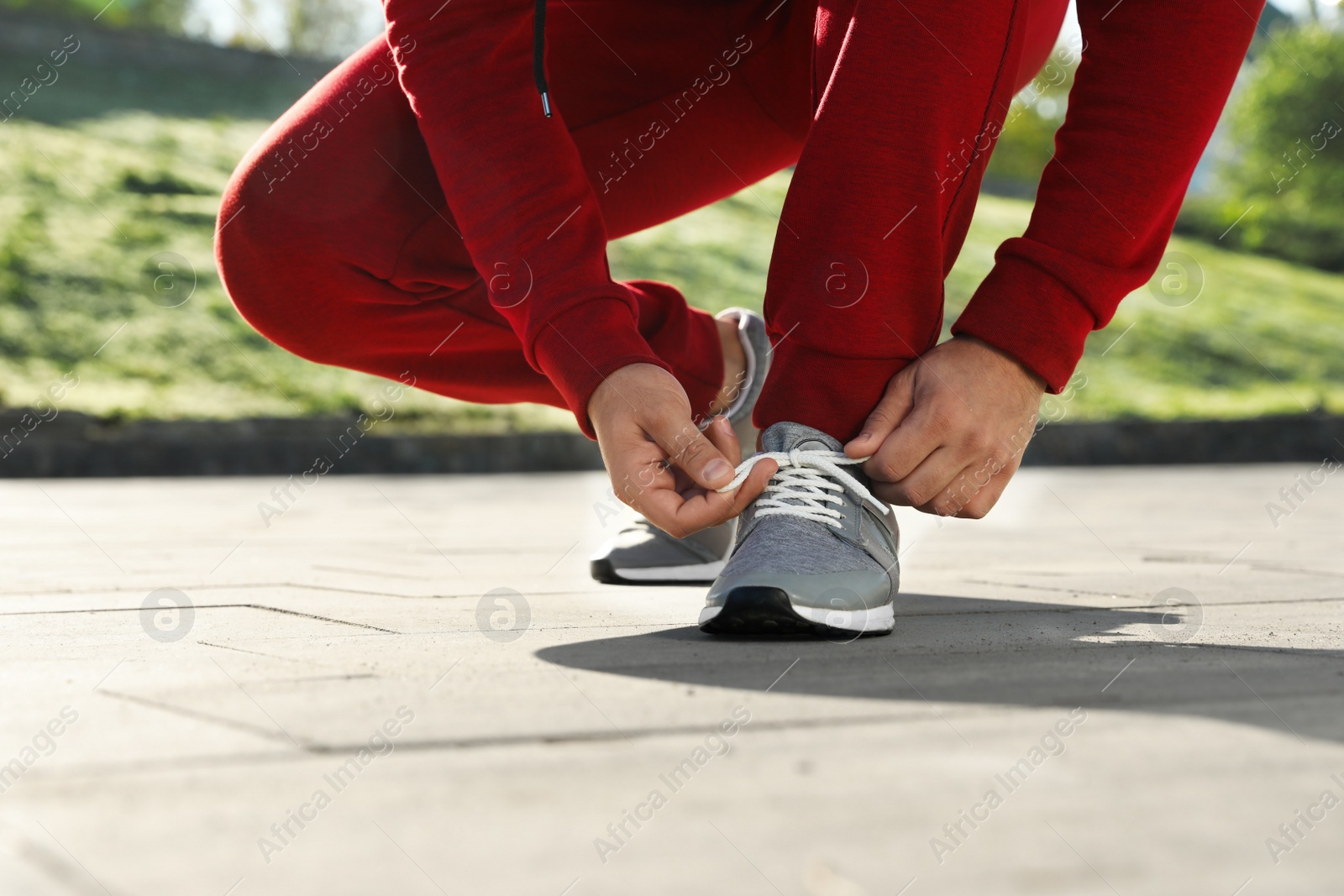 Photo of Sporty man tying shoelaces before running outdoors